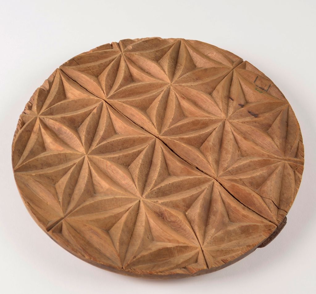 Sirkelformet treplate med geometrisk mønster utskåret. Foto. 