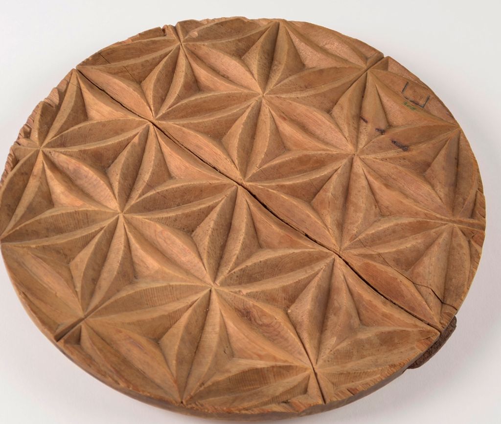 Sirkelformet treplate med geometrisk mønster utskåret. Foto.