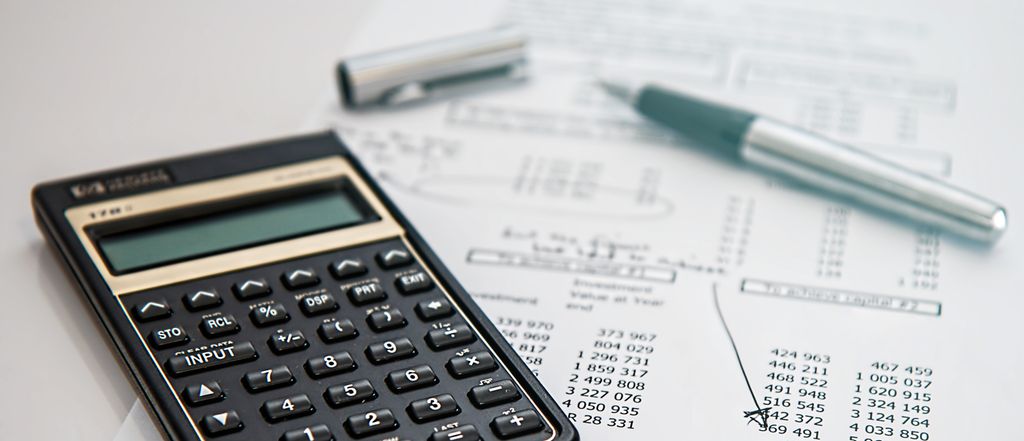 Kalkulator over ark med tall. Foto.