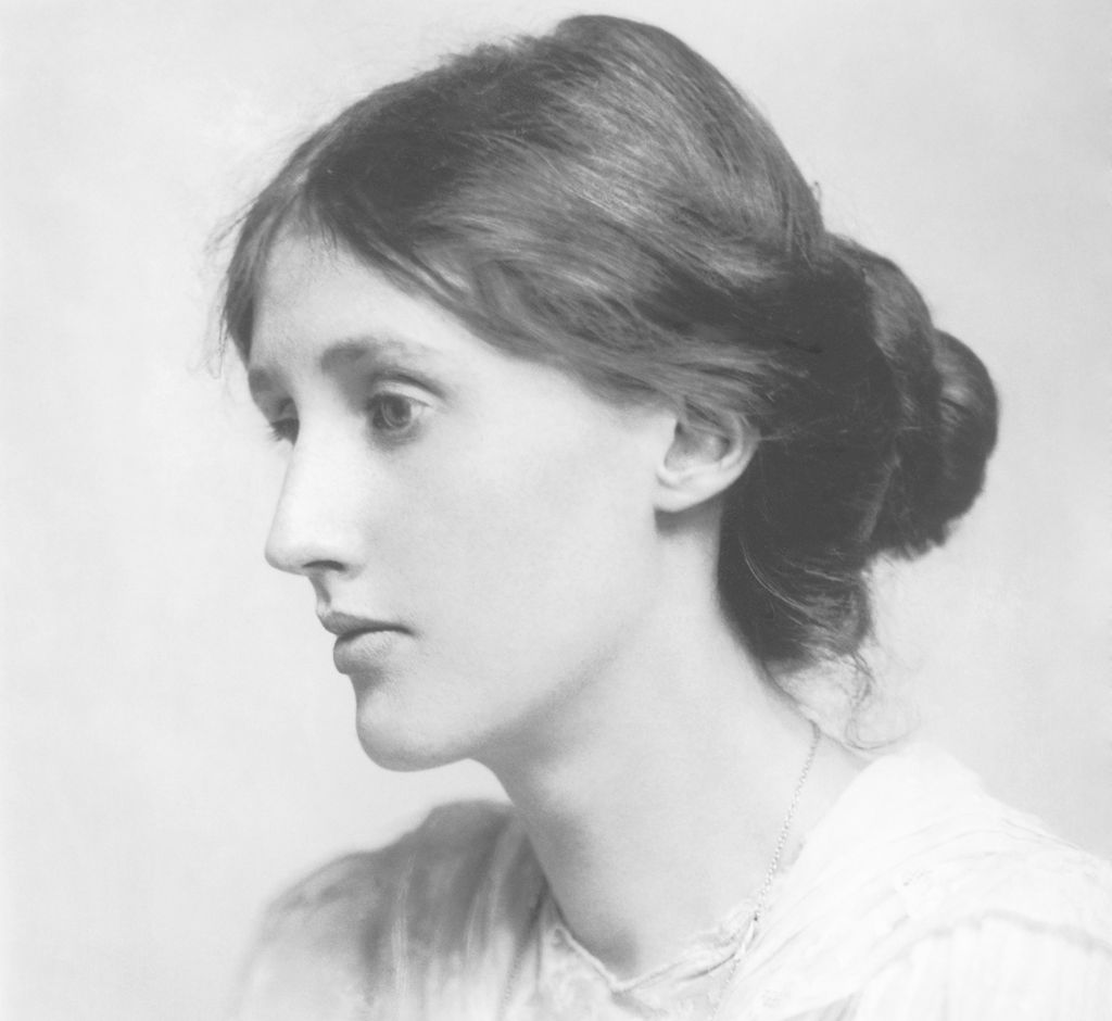 Photo: Portrait of a young woman. She has dark hair, gathered in a bun at the back. She has a serious expression. She is wearing a white blouse.