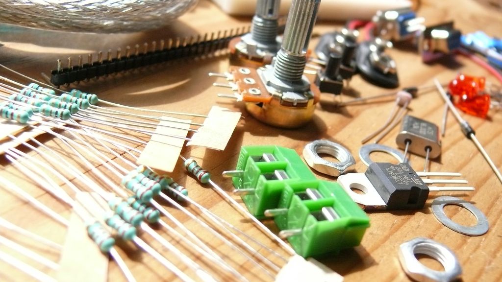 Forskjellige elektroniske komponenter ligger strødd på et bord. Foto.