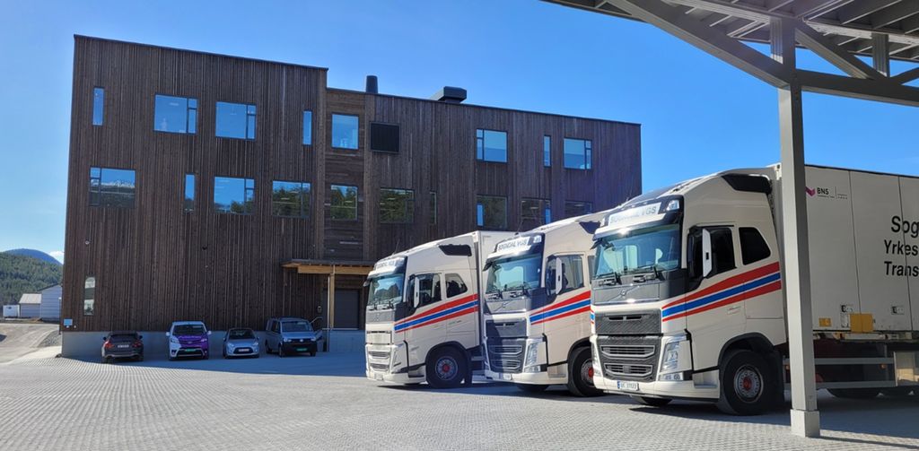 Hvite lastebiler som står parkert på en parkeringsplass. Foto.