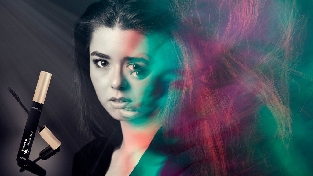 En falsk maskarareklame. I venstre del av bildet er det en maskara fra FakeUp og et portrett av ei jente. Fra midten av bildet forvrenges ansiktet til jenta. Håret er bustete og har rødt og grønt lys på seg. Foto.