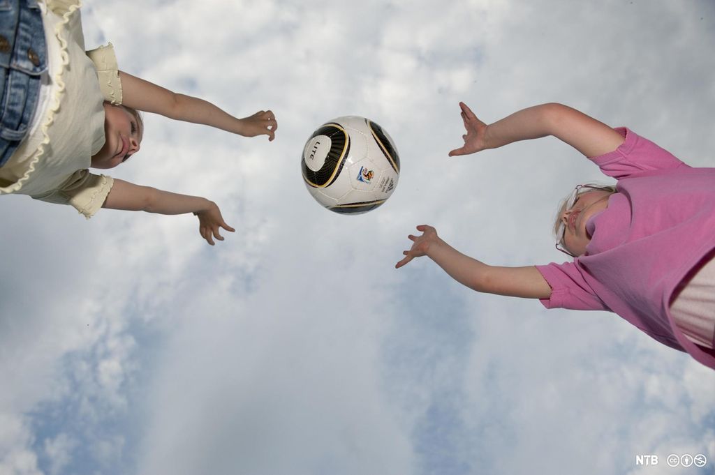 To jenter kaster en ball mellom seg. Foto.