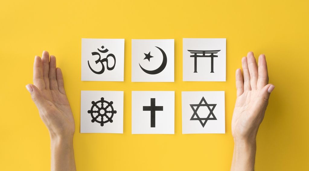 Seks religiøse symboler på hver sin lapp med to armer på hver side. Foto.
