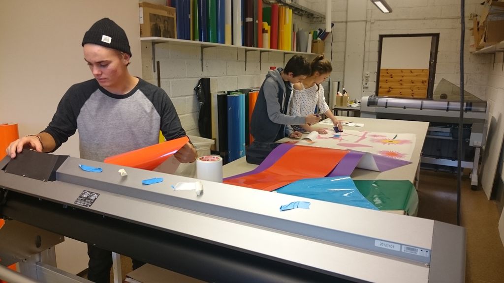 Fotografi av tre elever som jobber med foliedekor.