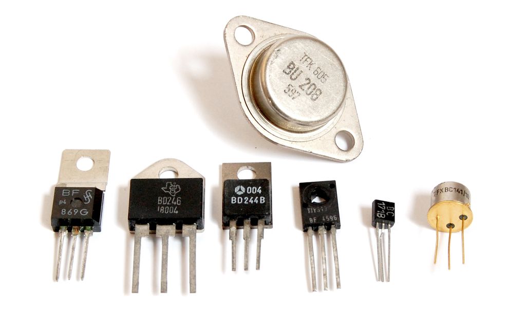 Sju transistorer av ulik størrelse og form. Alle transistorene har tre tilkoplingsbein. Foto