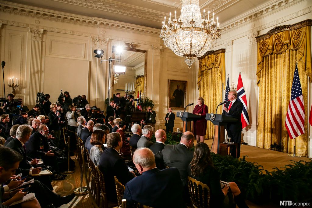 Erna Solberg og Donald Trump møter pressen i et staselig rom med lysekrone og tunge gullfargede gardiner. Foto. 