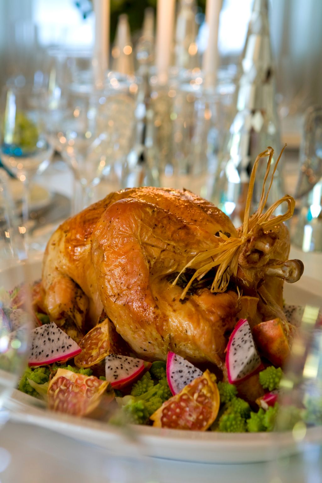 Helstekt kalkun på et fat pyntet med eksotiske frukter og grønnsaker. Foto.