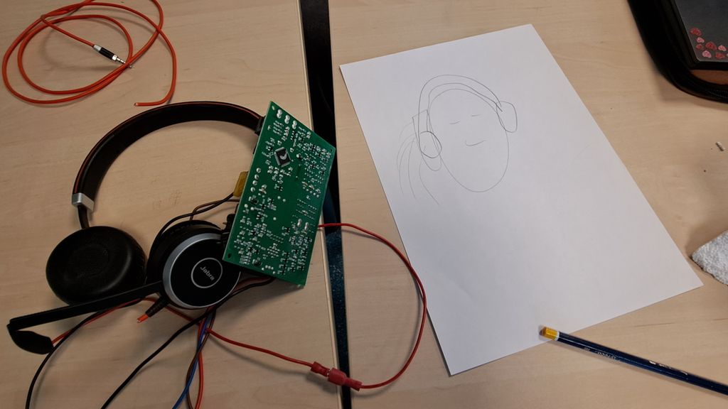 Hodetelefoner med ledninger og kretskort ved siden av en tegning av en person med hodetelefoner. Foto.