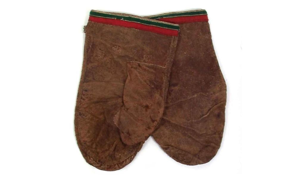 Fotografi av et par skinnvotter med bord i tekstil.