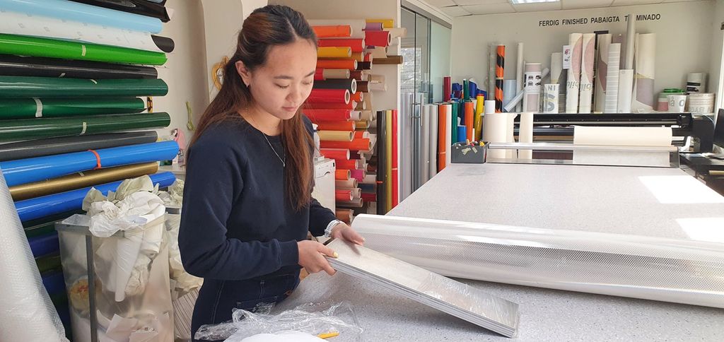 Ei jente som jobber med folie. Foto.