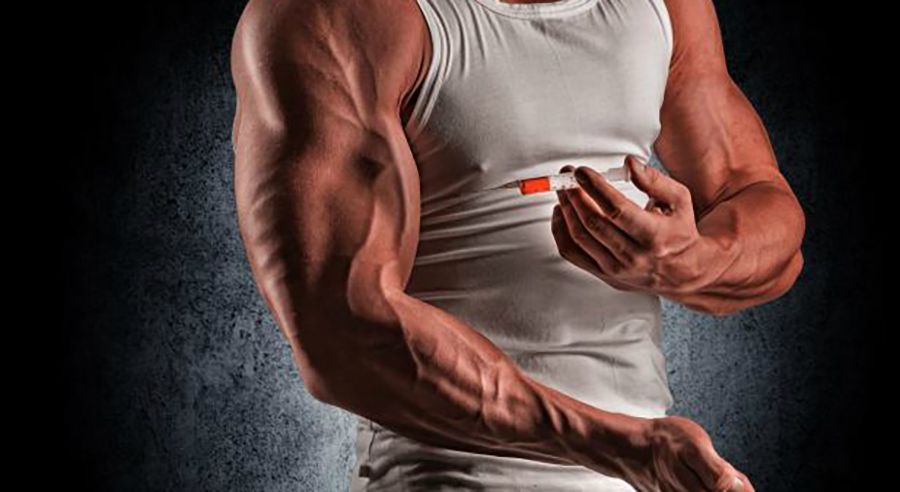 Muskelmann som held ei sprøyte framfor armen. Foto.