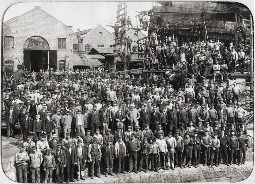 Mange arbeidere stilt opp til fotografering ved Akers Mekaniske Verksted i 1898. Her er også funksjonærer i litt finere klær. Foto. 