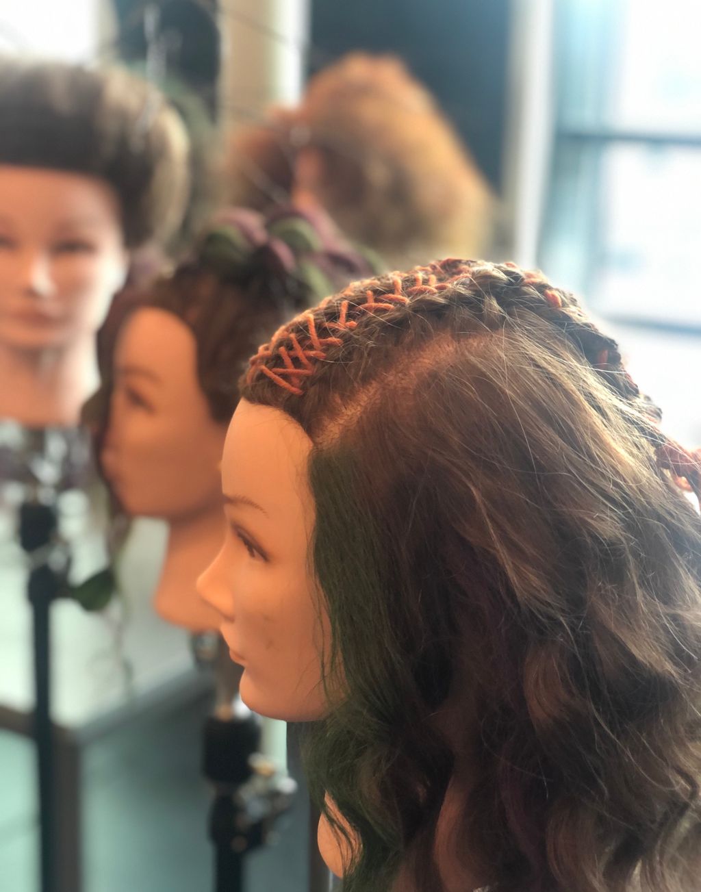 Dukkehoder med fletter og fargerike bånd i håret. Foto.