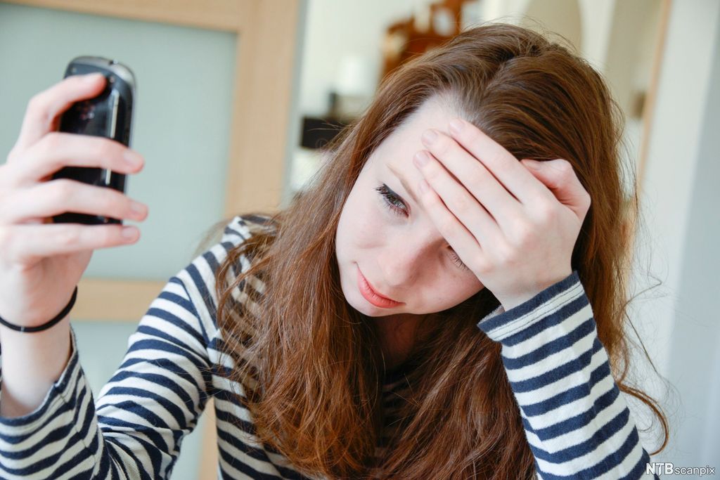 Jente som blir utsatt for mobbing via mobiltelefon. Foto.