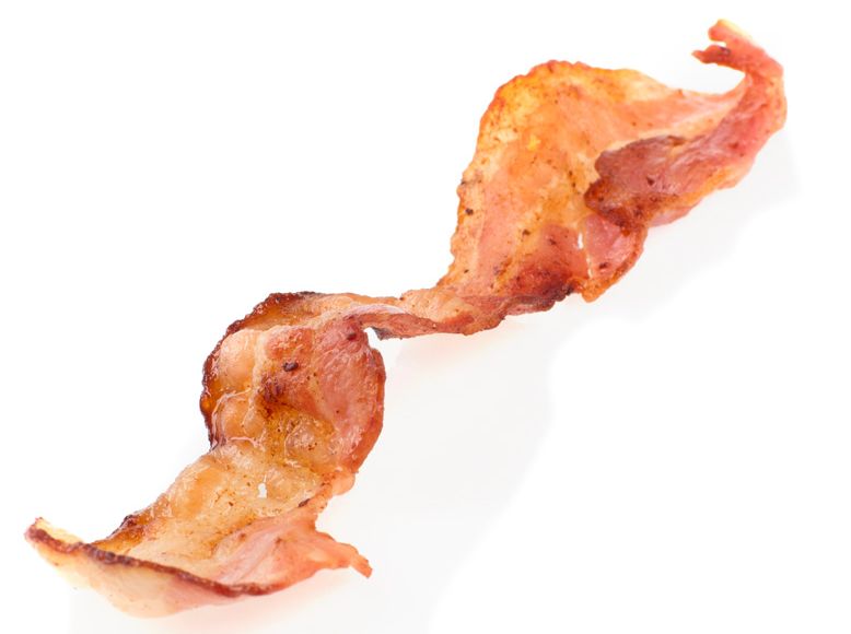 Ei steikt baconskive mot kvit bakgrunn. Foto.