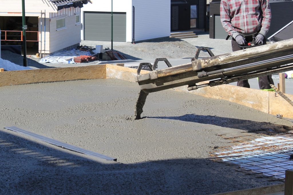 Flytende betong renner ut og blir til gulv. Foto.