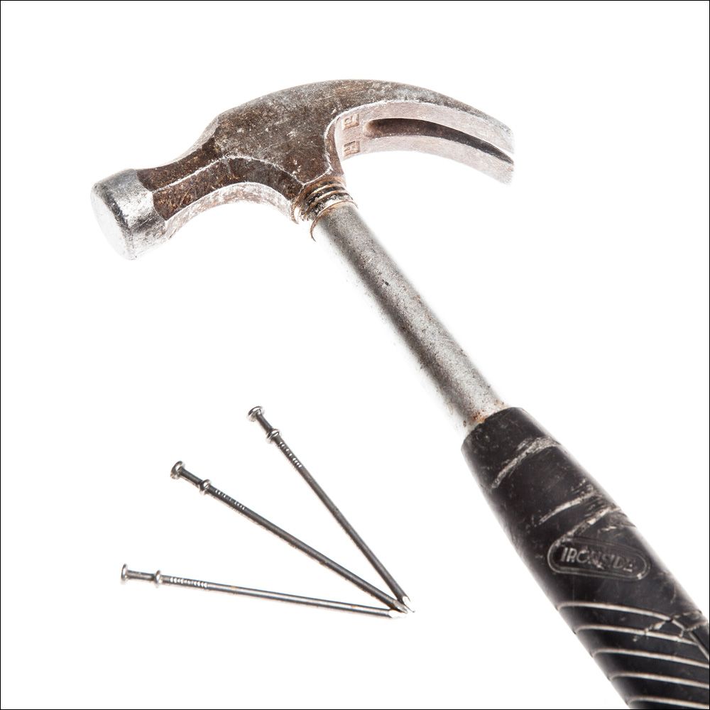 Hammer og tre spikre. Foto.