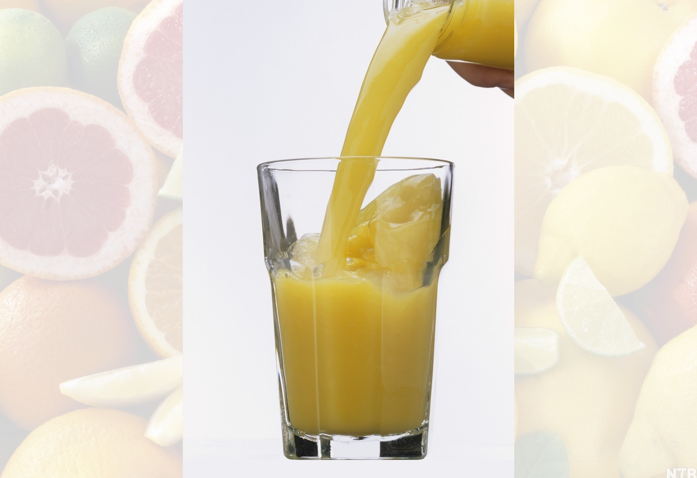 Gul væske helles opp i et glass med isbiter. Foto.