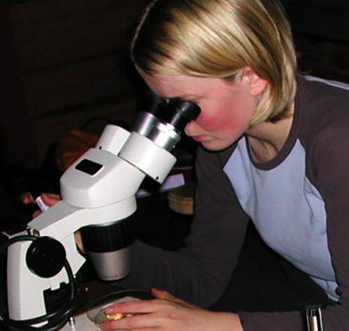 Jente ser i stereolupe. Foto.