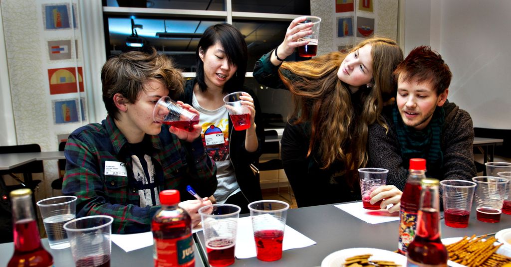 Fire ungdommer smaker på flere typer rødbrus. Foto.