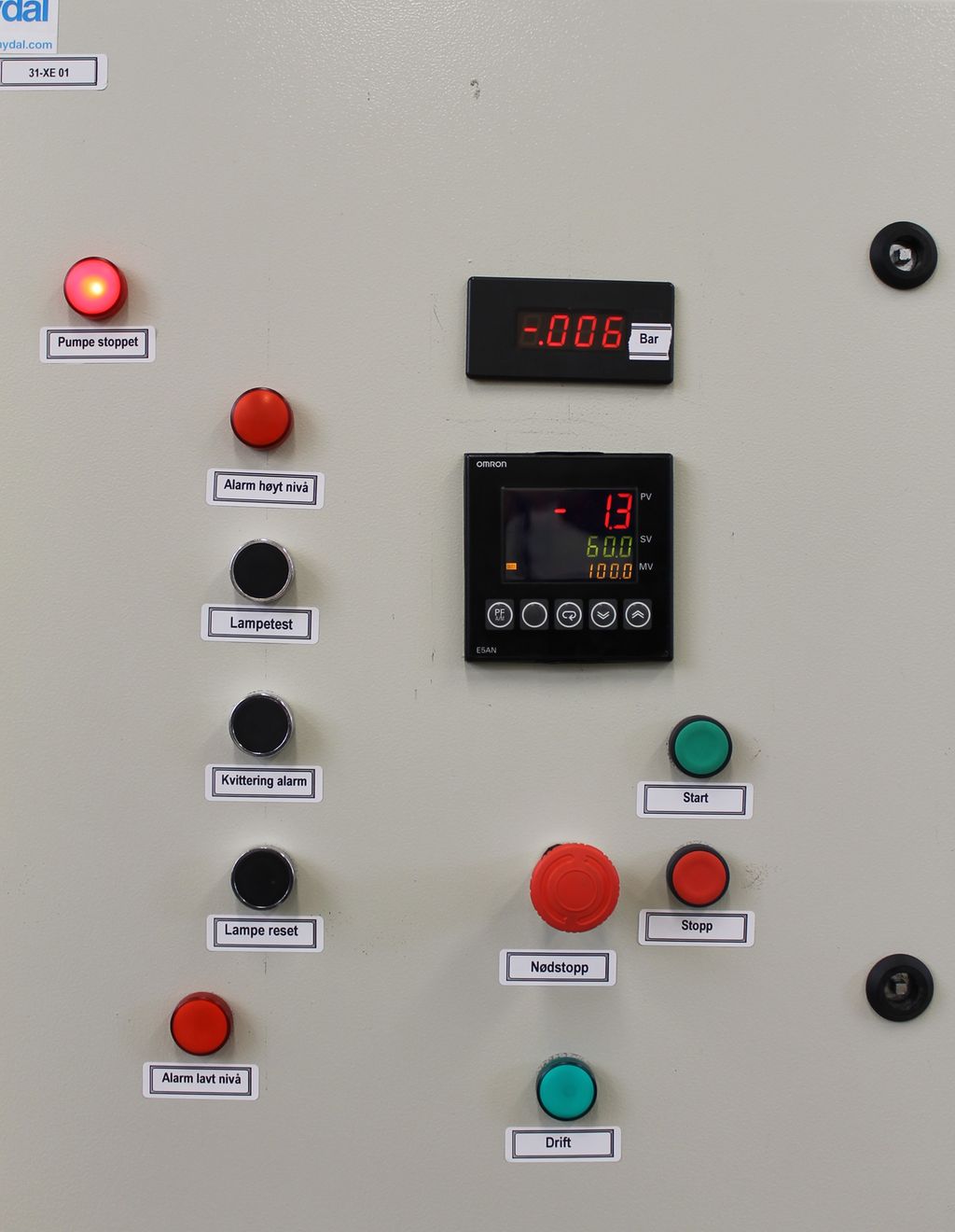 Brytere og signallamper. Bildet viser at de forskjellige lampene og bryterne har farger som stemmer med normens anbefaling. Denne tavledøren har blant annet lamper og brytere som følger normens anbefalinger: Grønn bryter starter, røde brytere stopper, og svarte brytere utfører andre funksjoner. Grønn lampe betyr at pumpen er i drift, og røde lamper betyr at pumpen er stoppet, eller at en alarm er utløst. Foto.