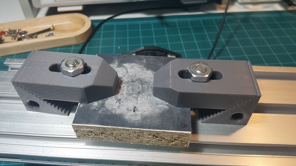 Firkanta arbeidsemne festa på et fresebord med spennjern på to av sidene. Foto.