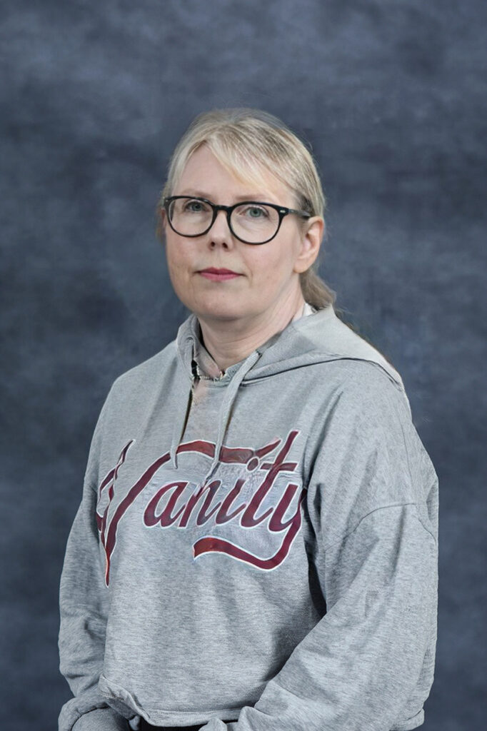 Lys kvinne med briller og alvorlig ansiktsuttrykk. Foto.