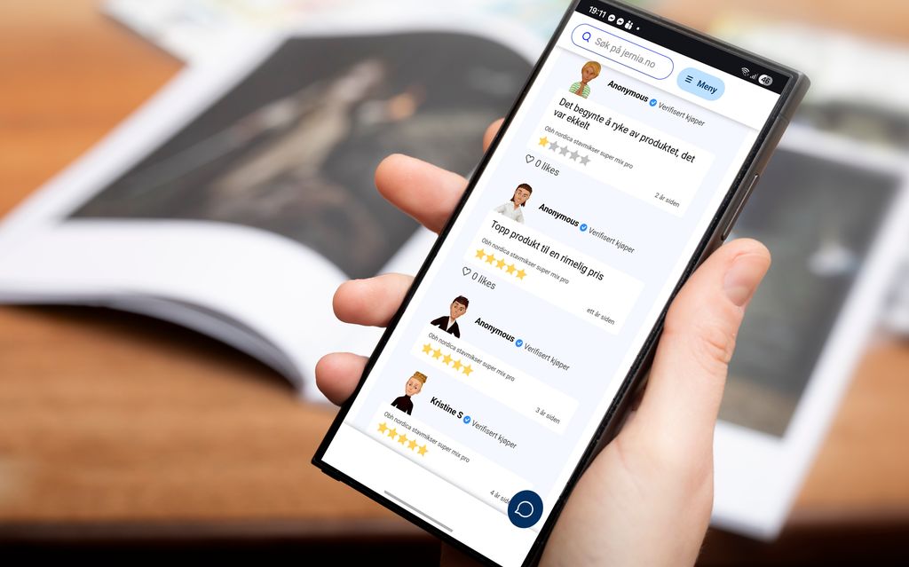 Ei hånd holder en mobiltelefon. På skjermen vises det ei nettside med forskjellige kundeanmeldelser av en stavmikser. Foto.