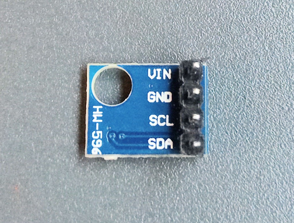 Elektronisk komponent med fire tilkoplinger. De har betegnelsene VIN, GND, SCL og SDA. Foto