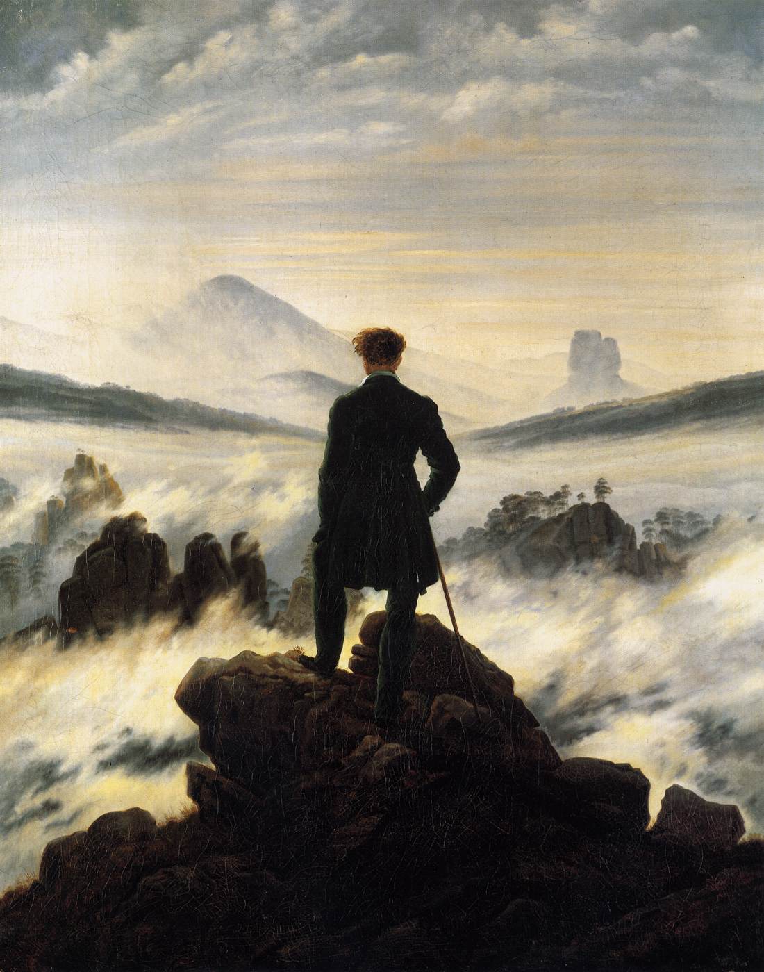 Painting: We see a man standing on a cliff, looking out over a landscape that is partly shrouded in fog. He wears a suit and has a walking stick. 