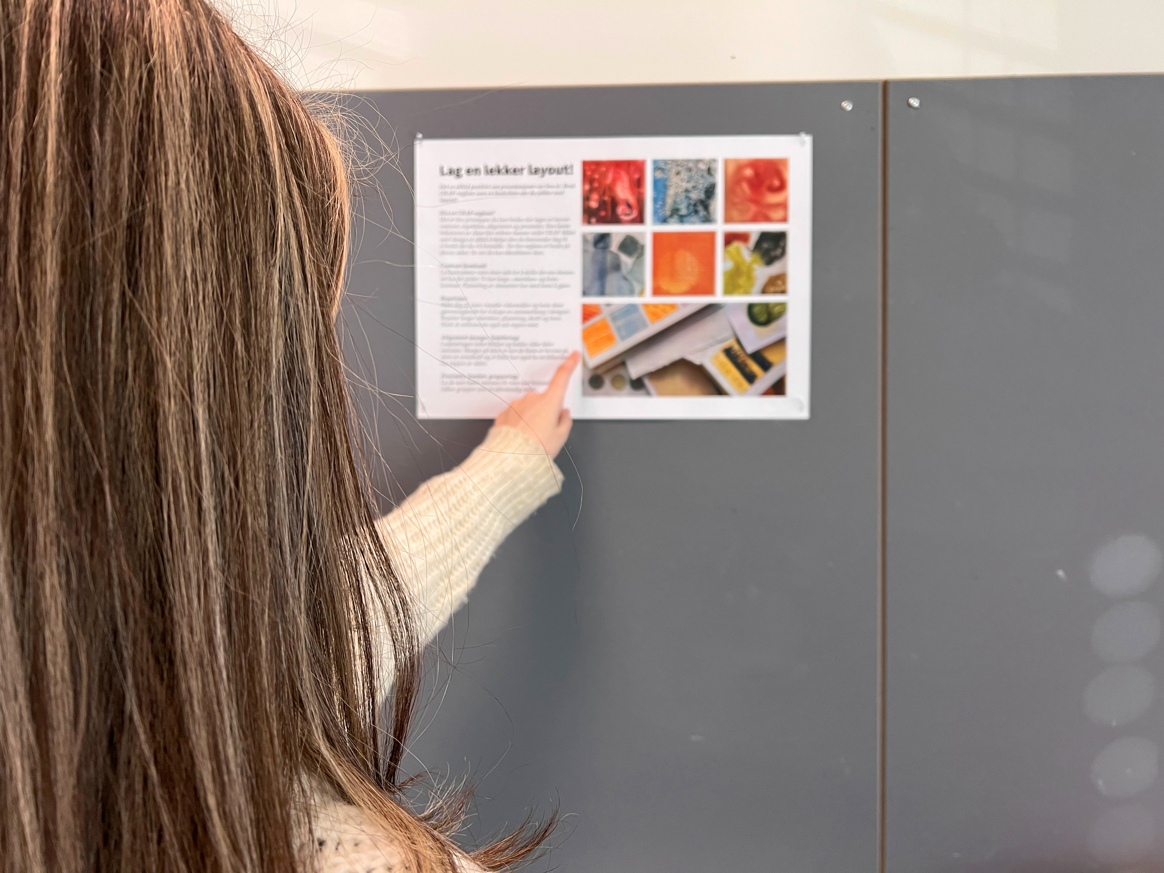 Jente studerer en plakat med tekst og bilder. Foto.