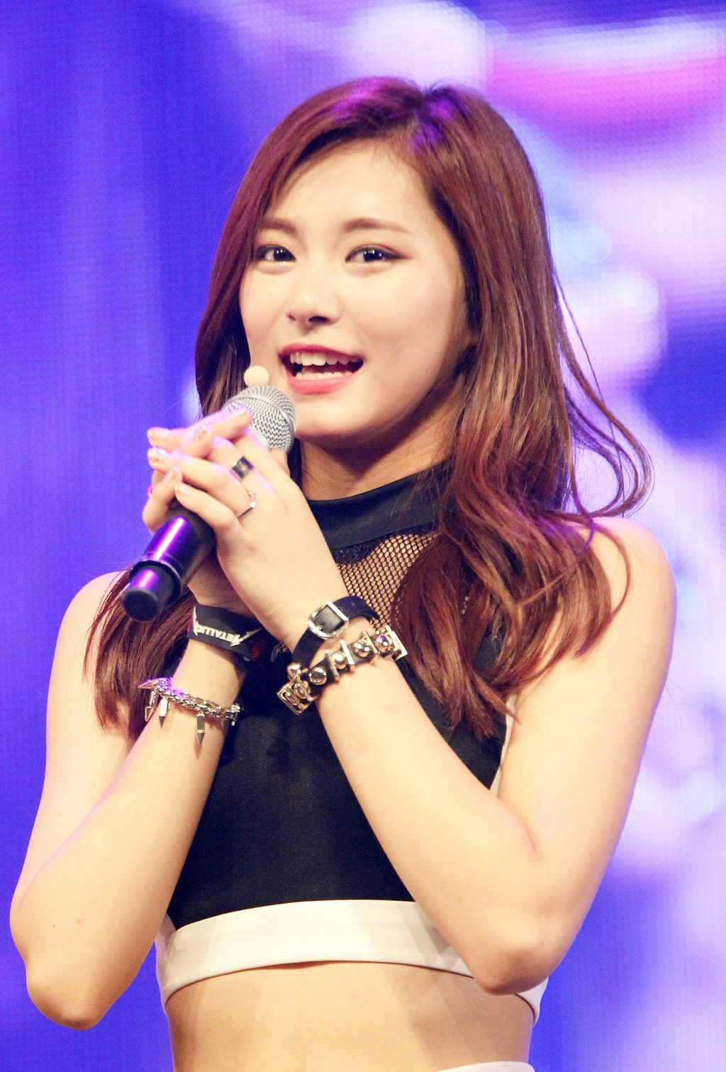 Kinesisk jente synger i mikrofon. Foto.