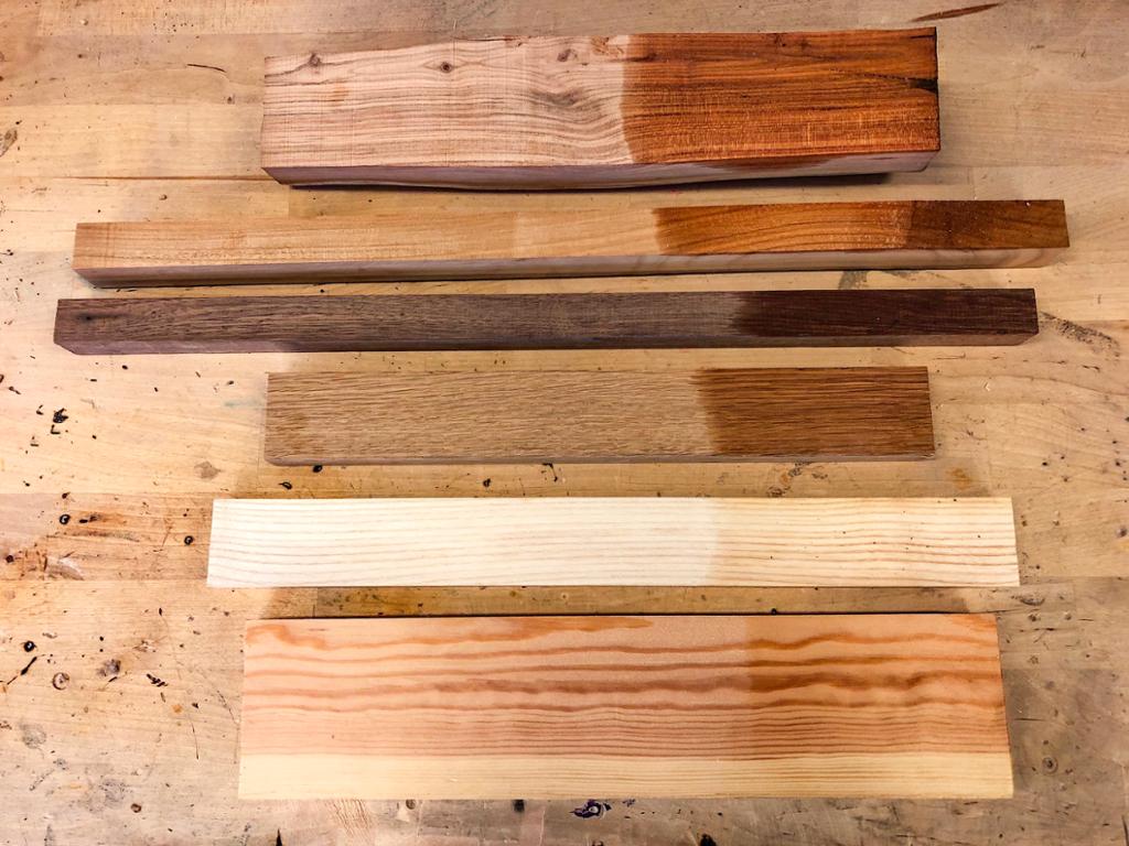 Materialprøver av ulike treslag. Deler av prøvene er fuktet. Foto.