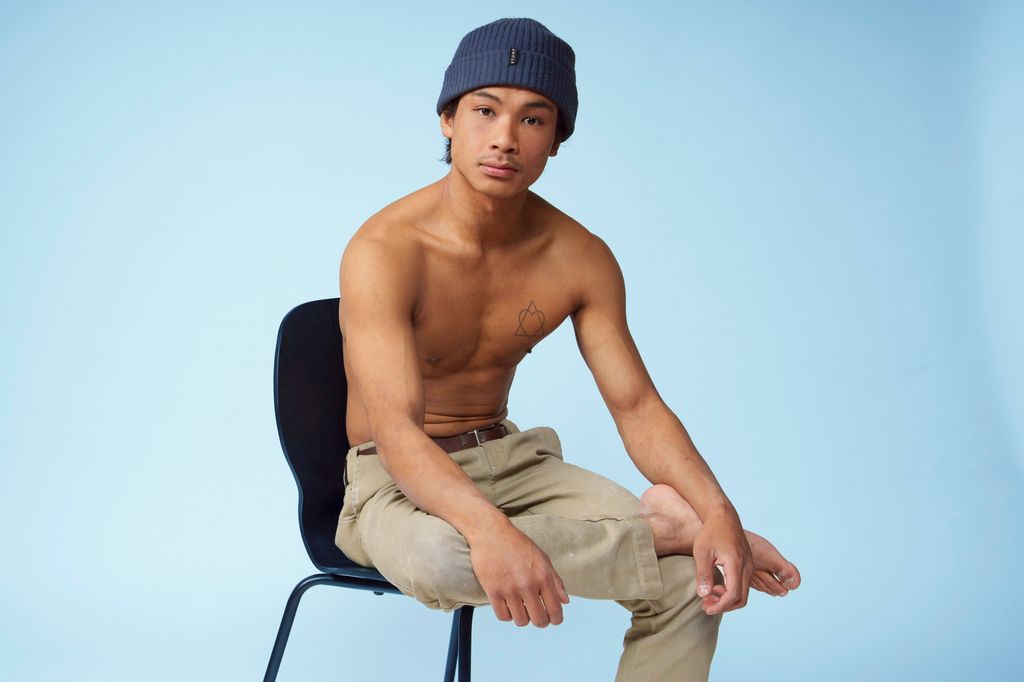 Mannleg modell sit på ein stol. Foto.