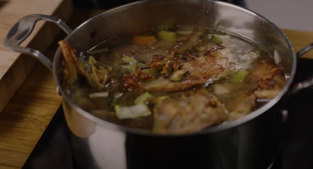 Kyllingkraft i en kasserolle som står på en koketopp. Foto.