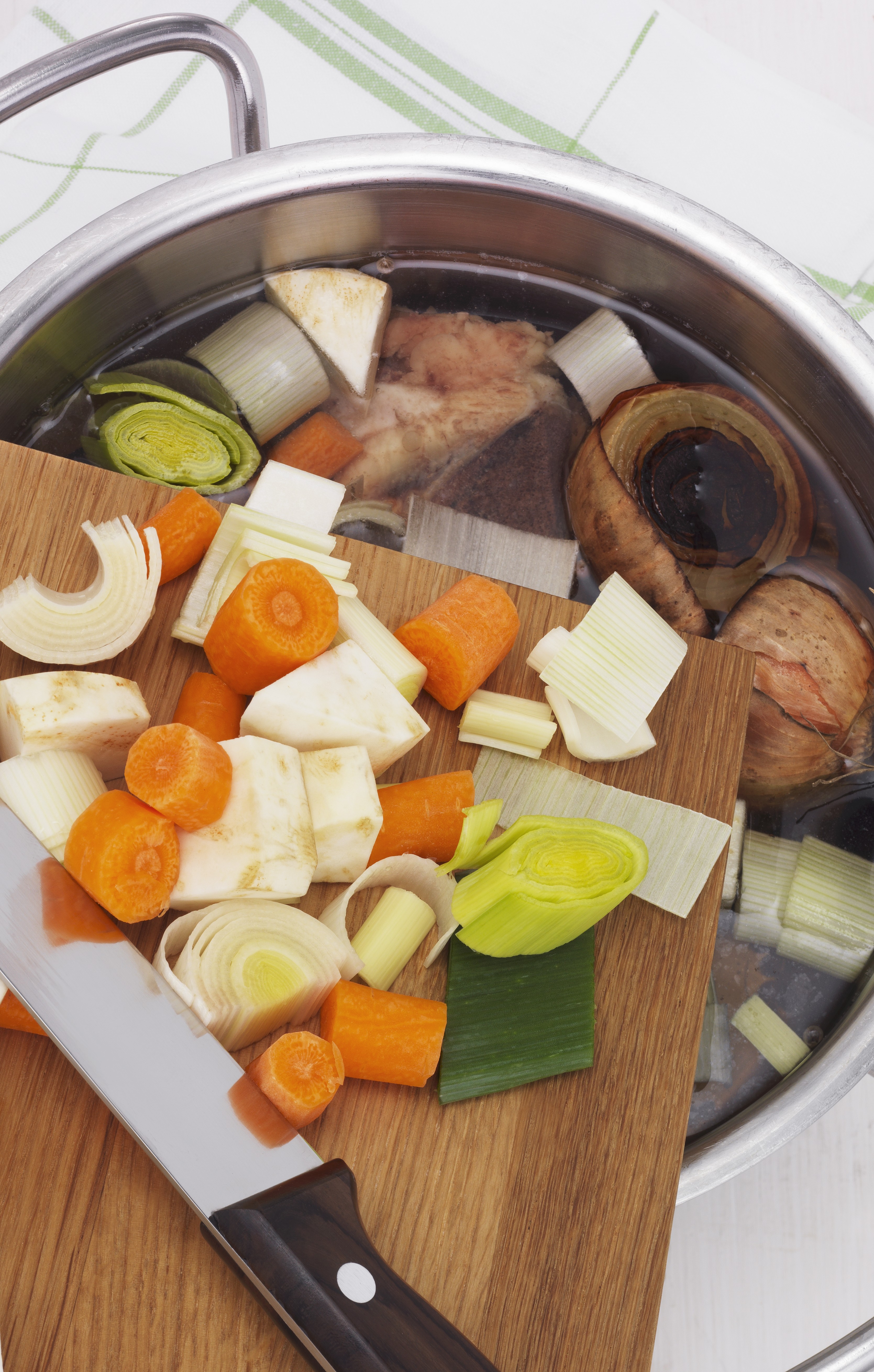 Oppkuttede grønnsaker på vei fra skjærefjøl til kjele med vann. Foto.