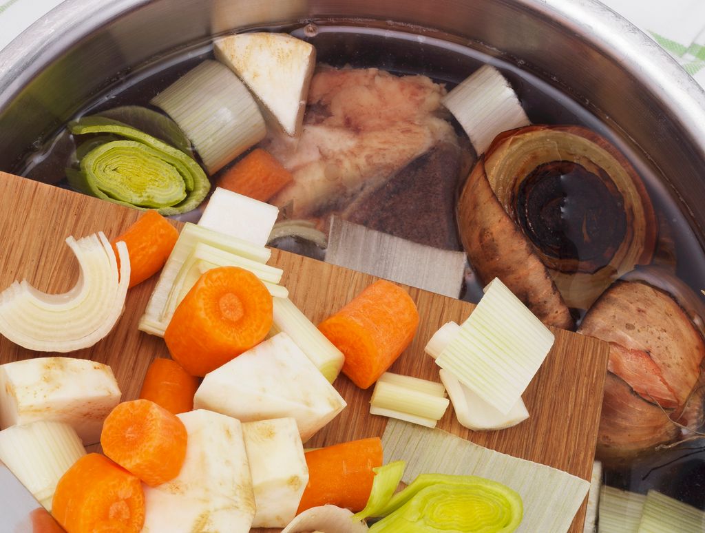 Oppkuttede grønnsaker på vei fra skjærefjøl til kjele med vann. Foto.