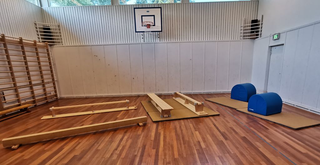 Benker og voltputer er spredt utover gulvet i en gymsal. Foto.