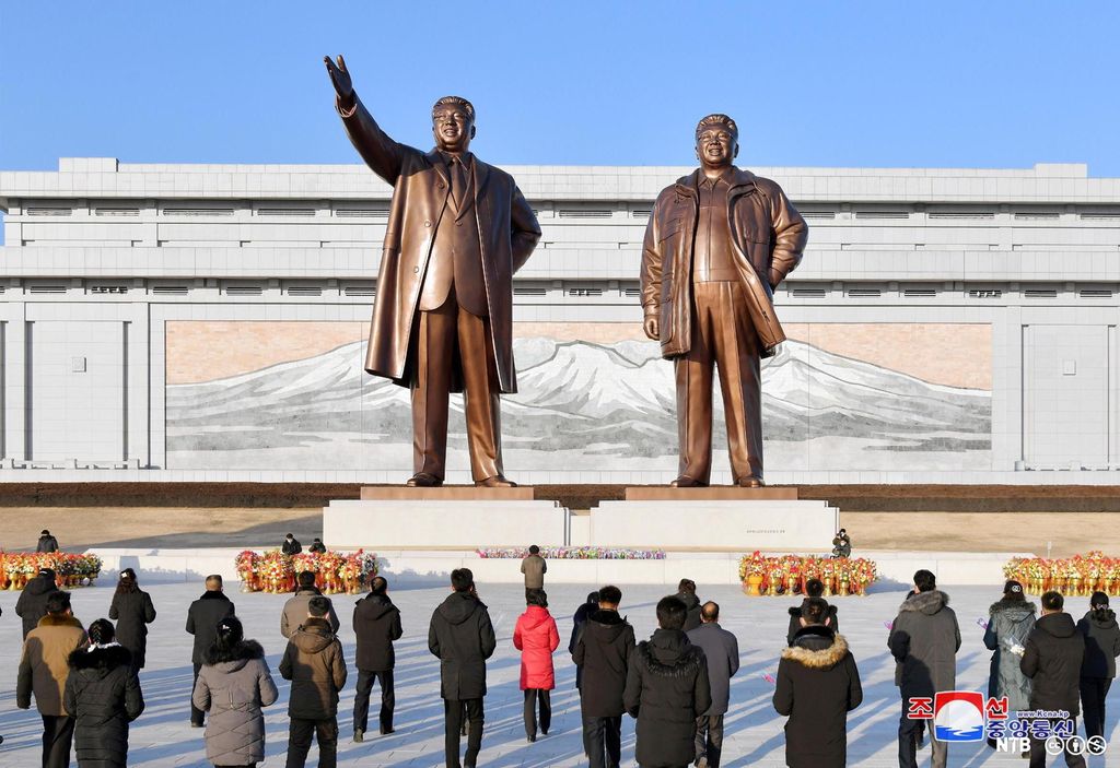 En stor åpen plass med to store statuer av nåværende leder Kim Il-sung og forrige leder Kim Jong-il. Foran statuene står vanlige nordkoreanere og gir sin hyllest til lederne. Foto.