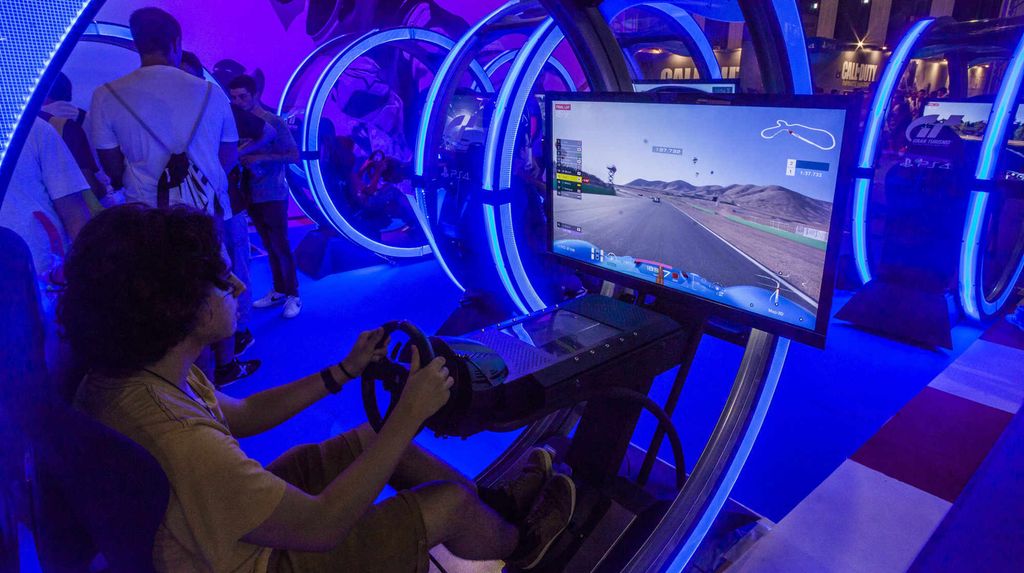 Ungdom sitter foran PC-spill i blått lys. Foto.