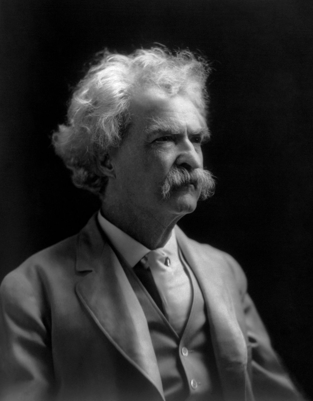 Portrait of Mark Twain.  He is an older man with bushy white hair, eyebrows, and moustache. Photo.