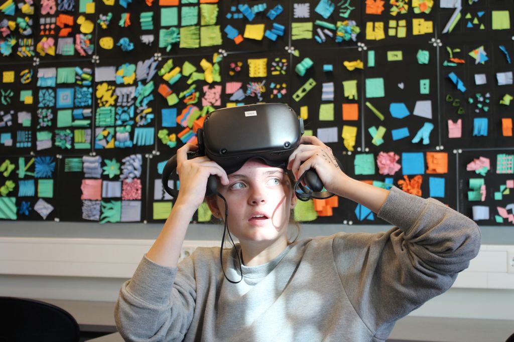 Uttrykksfull jente med VR-briller på hodet. Foto.