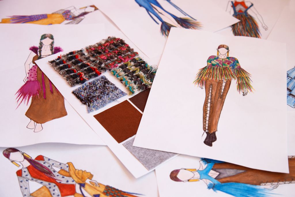 Skisser av klesdesign sammen med materialprøver. Foto.