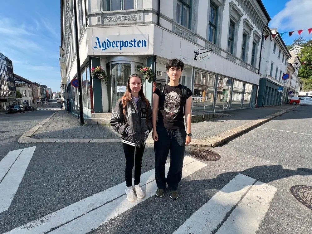To jenter står utenfor lokalet til avisa Agderposten. Foto.