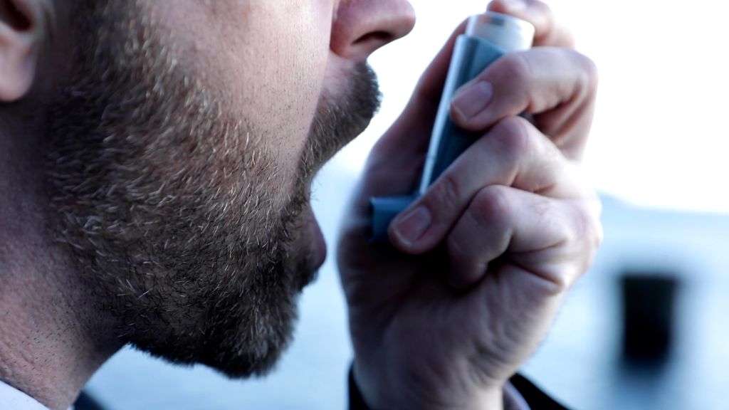 Mann bruker inhalator. Foto.