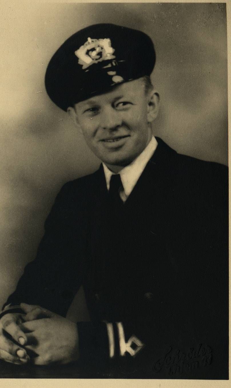 Smilende mann i skipsuniform. Svart-hvitt foto. 