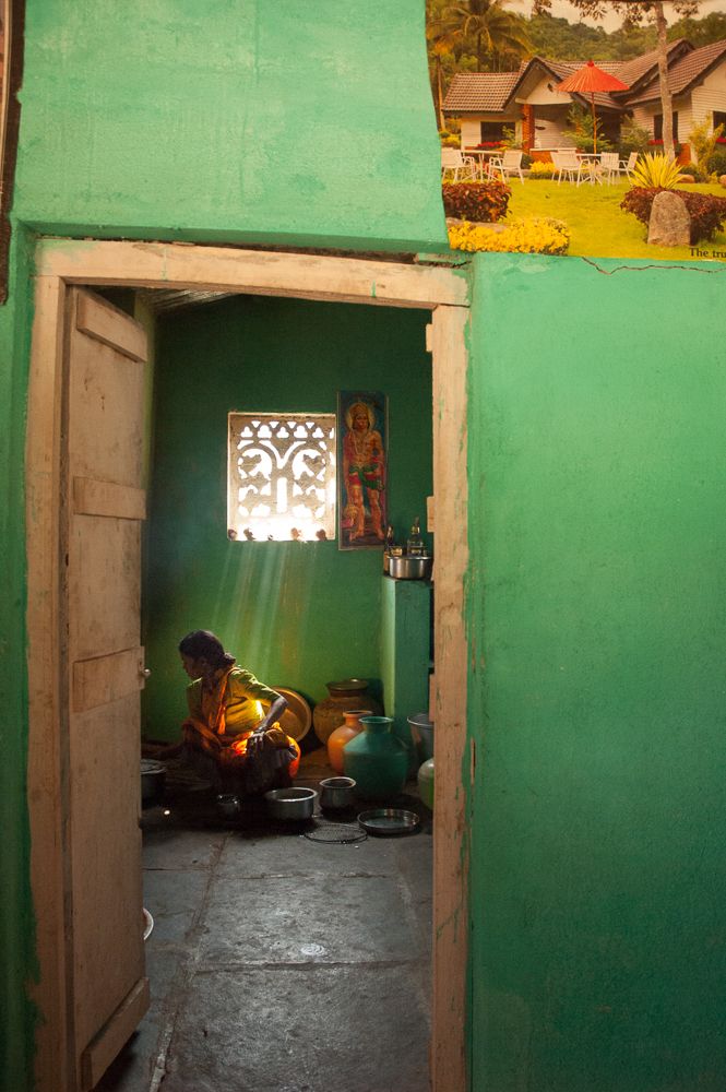 Vi ser en kvinne gjennom døra inn til et annet rom. Fotografi.