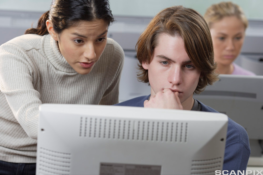 To elever studerer noe på en pc-skjerm. Foto.